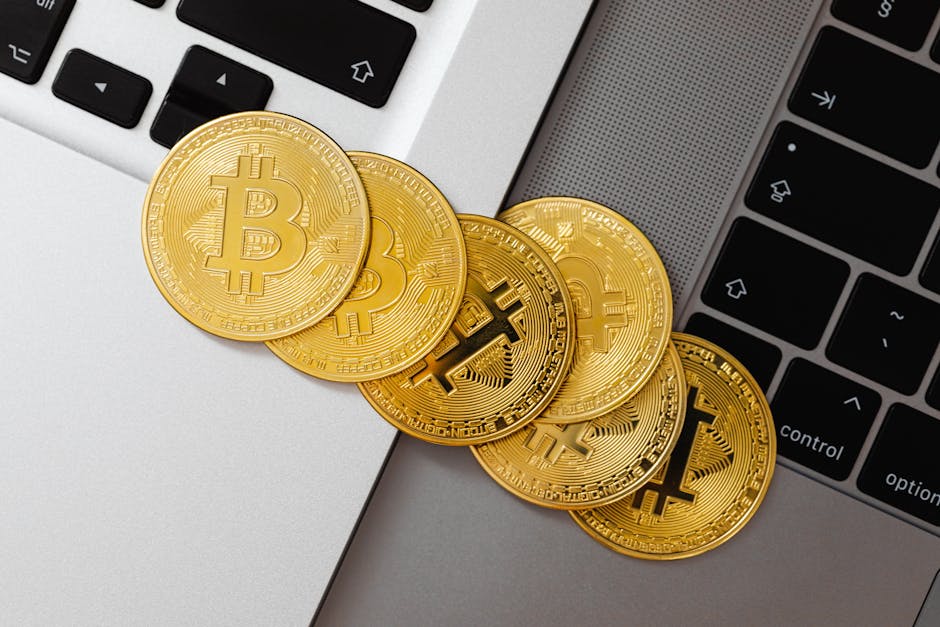 Bitcoin coins resting on a laptop keyboard