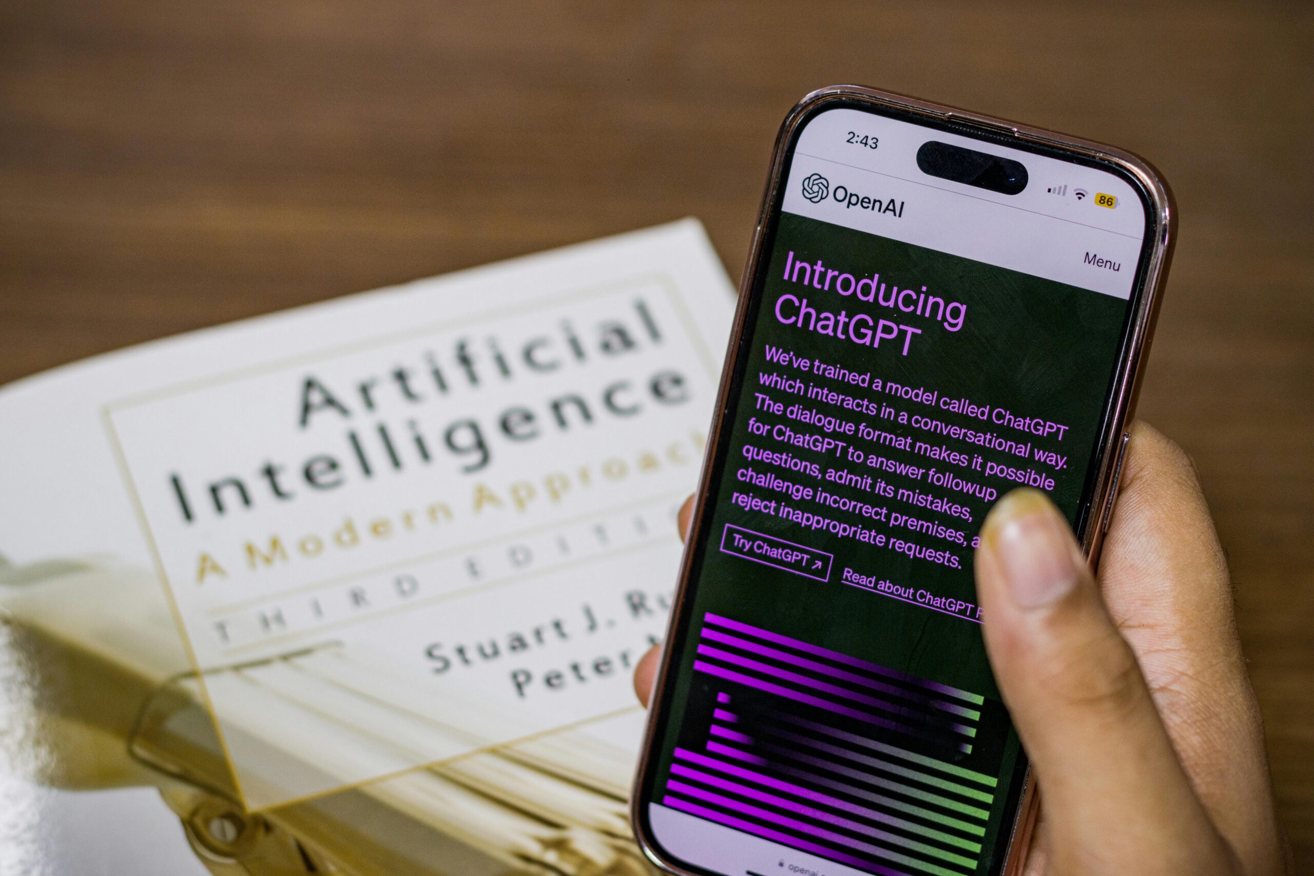 A person holding a smartphone with AI interface, representing the shift toward agent-based mobile experiences