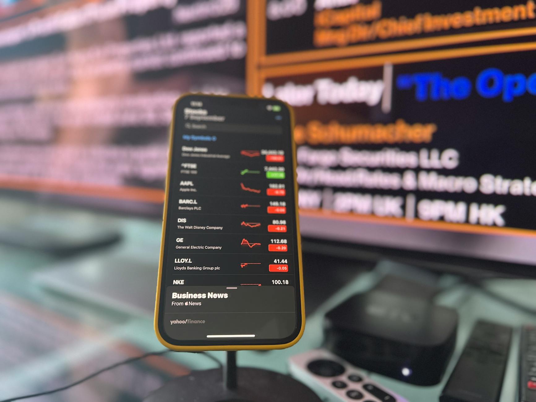 Smartphone showing live stock market updates in a London office