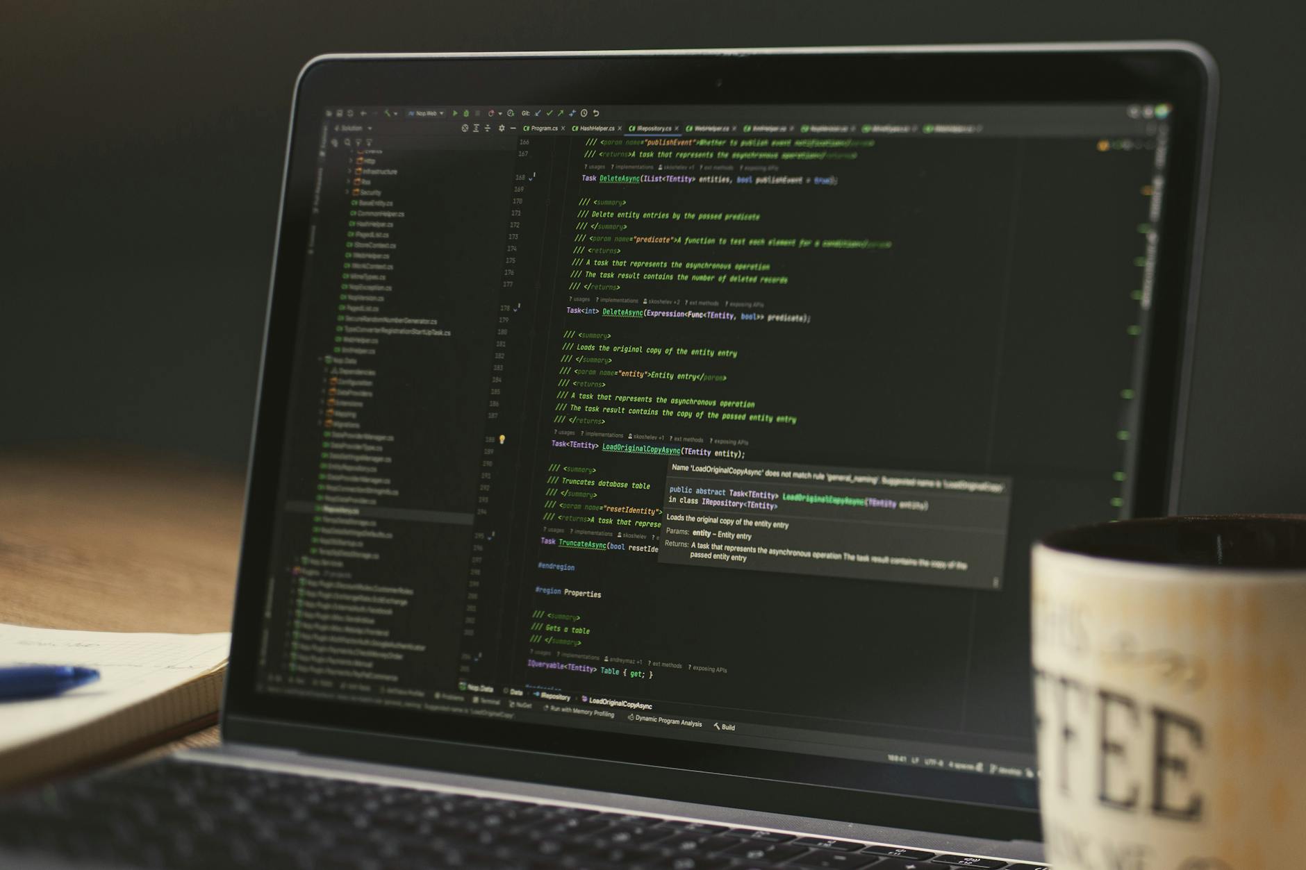 Developer working on a laptop with code on screen