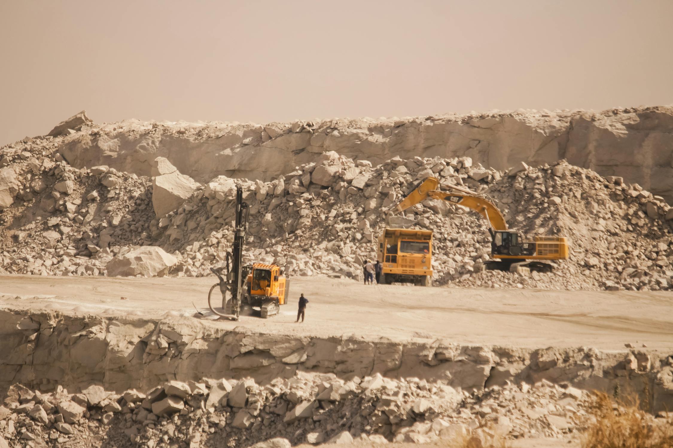 Heavy machinery and drilling rig at work in a large quarry site