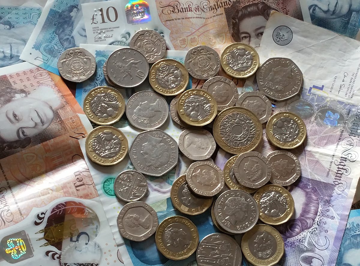 British Pound Sterling coins and banknotes spread out on a surface