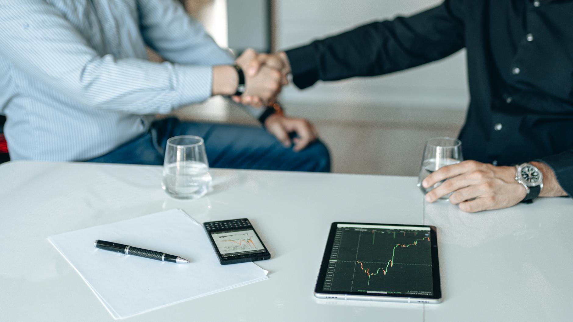 Business professionals shaking hands after completing a corporate deal