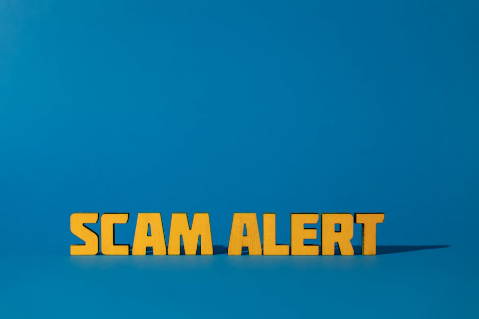 A business person holding a scam alert sign over a laptop, representing investment fraud warning
