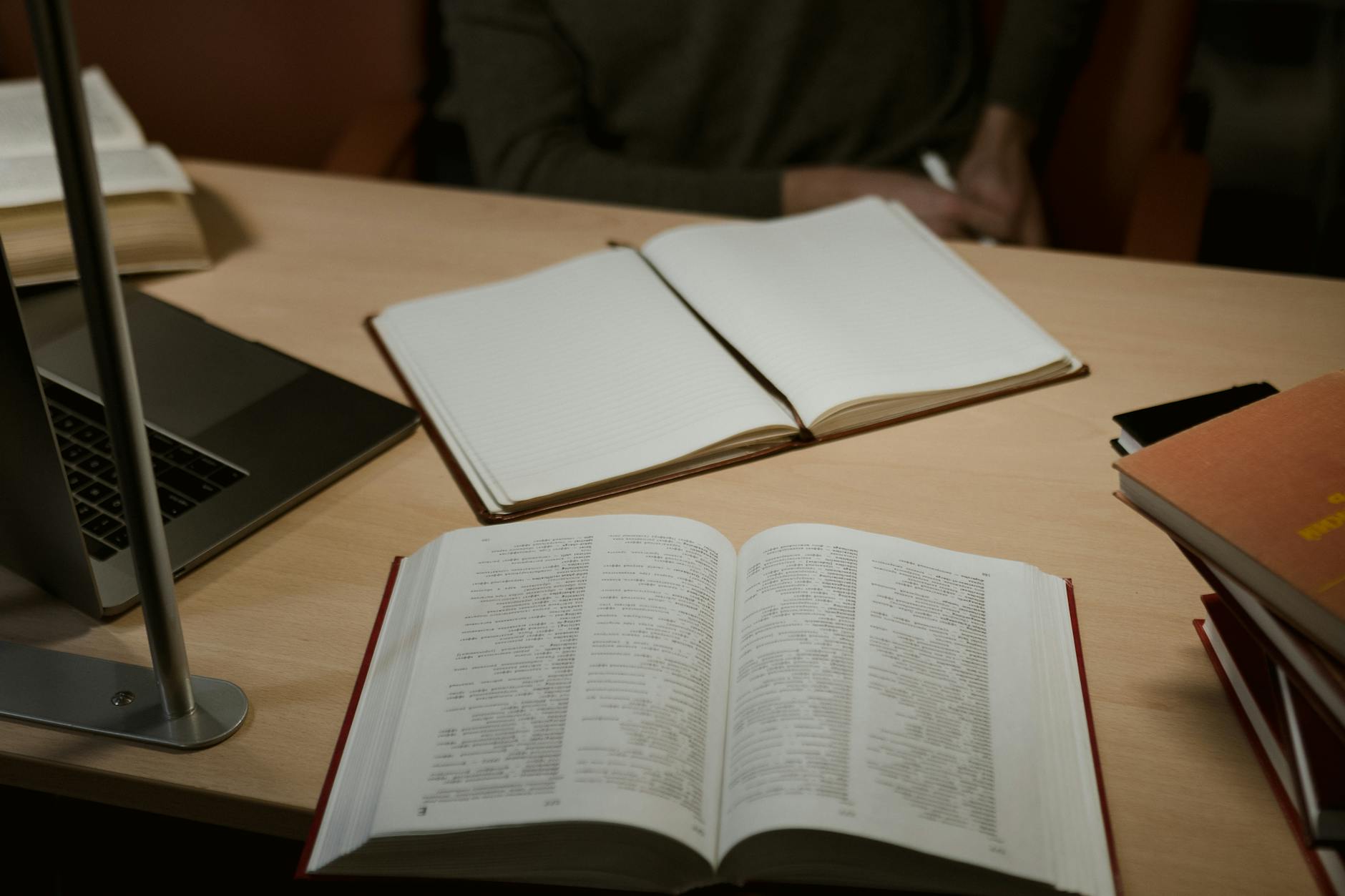 Open books and a laptop on a desk representing how AI processes and holds information in memory