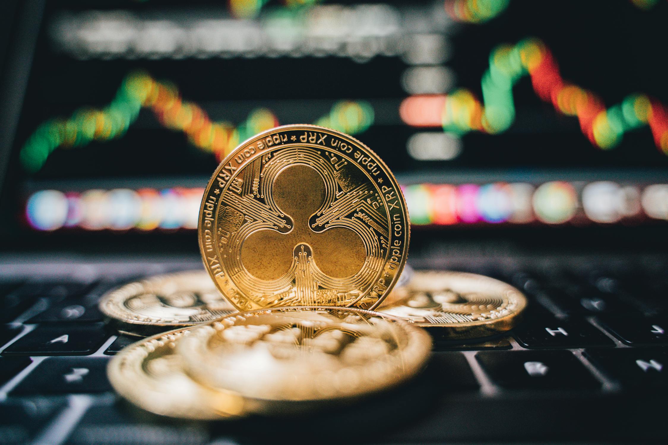 Golden XRP cryptocurrency coins on a laptop keyboard representing cross-border payments