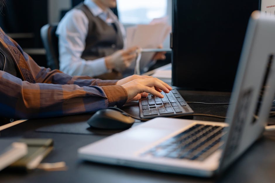 Office workers collaborating at computer workstations in a modern workspace