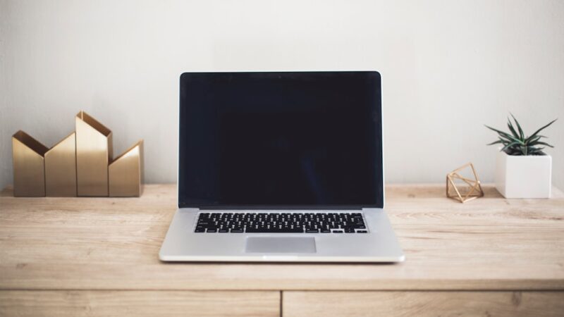AI email rewriting concept showing an email being revised on a laptop with clear before and after text