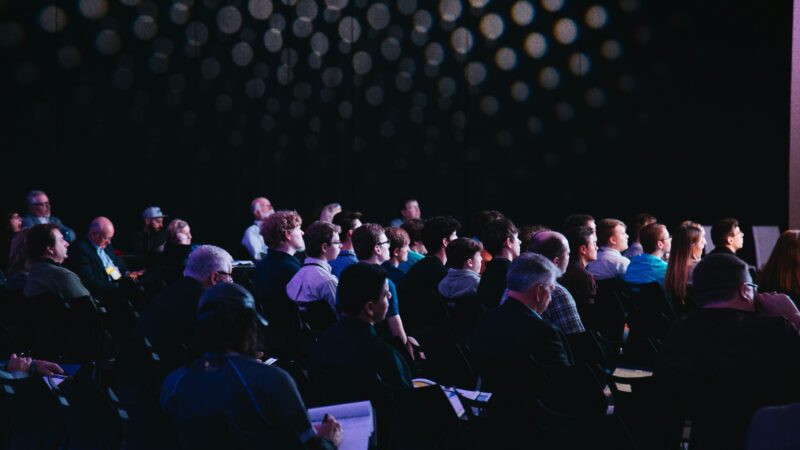 Shareholders raising hands to vote at an annual general meeting
