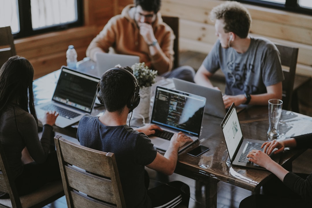 Team collaborating around laptops in a modern office workspace