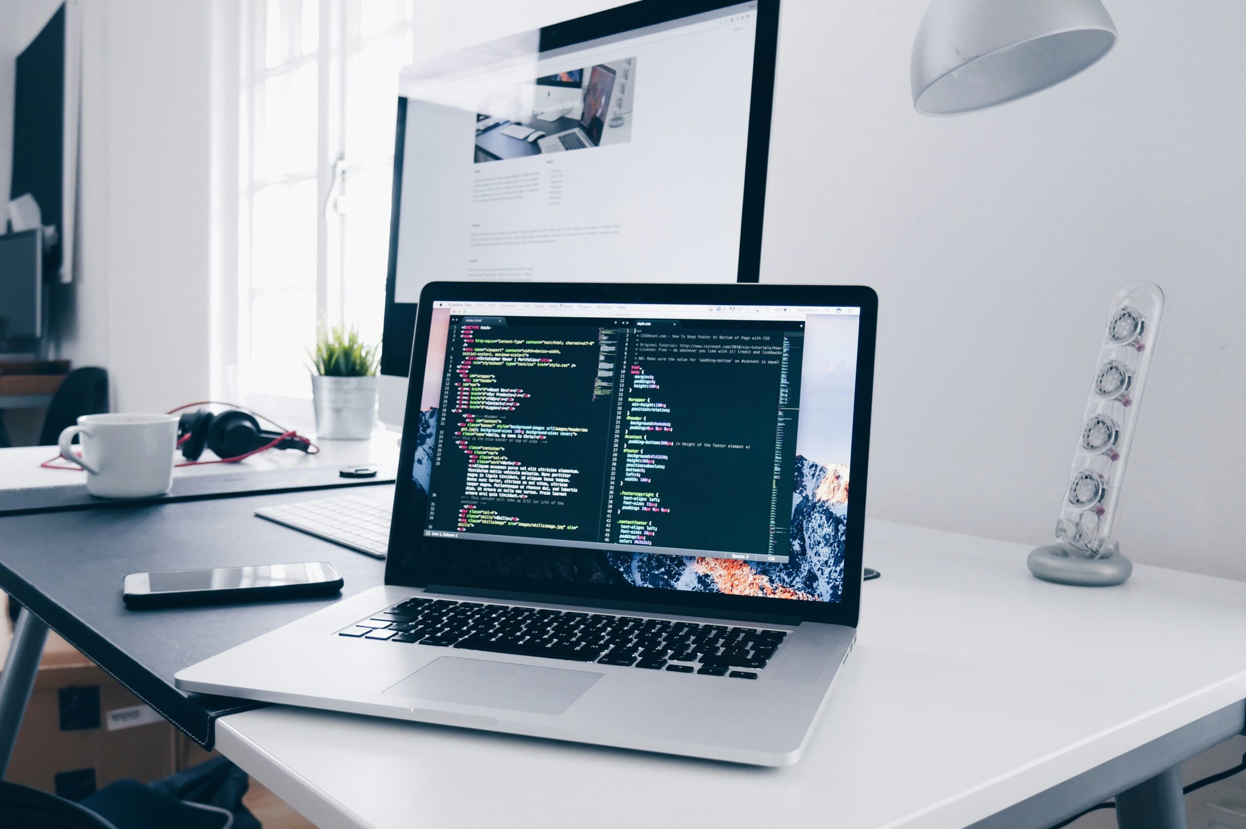Developer working on laptop with code and browser windows