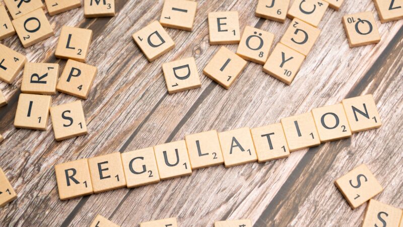 Letter tiles spelling REGULATION, representing AI governance and policy