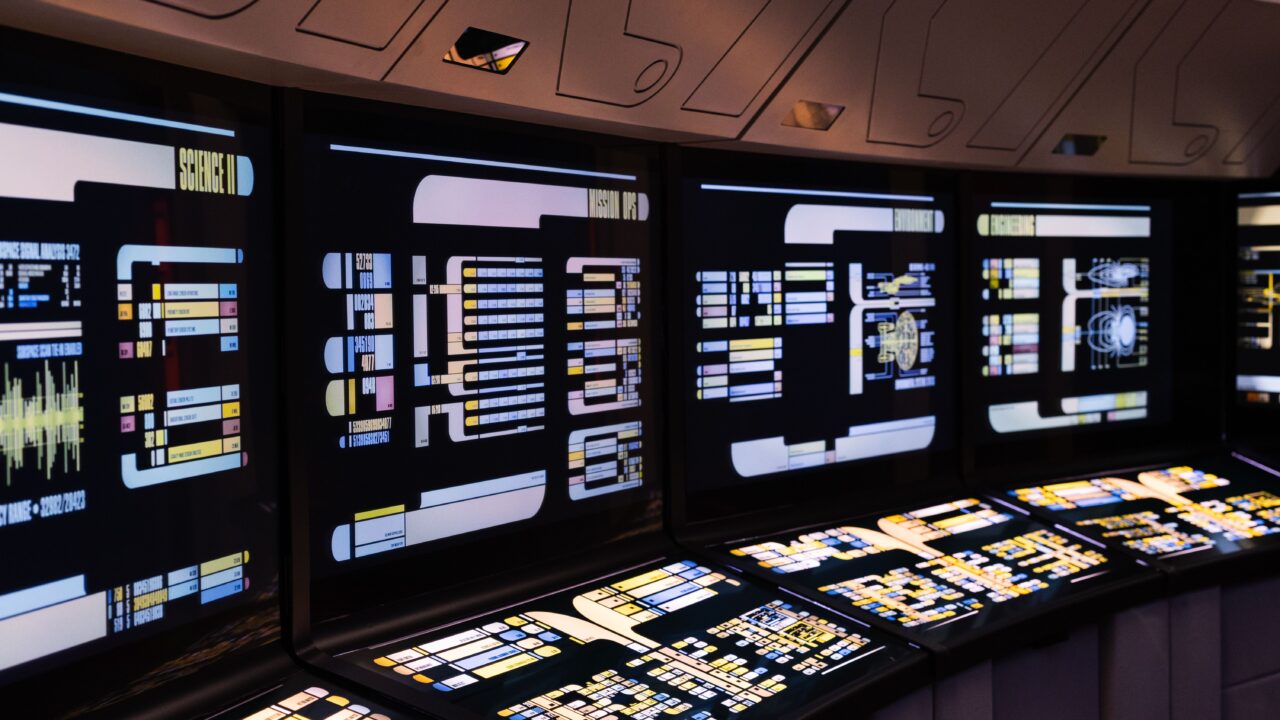 Control room with banks of monitors, representing an AI agent control layer