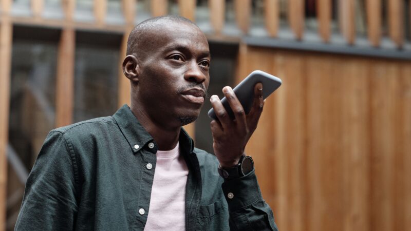 Person speaking to a voice assistant on a phone, representing personalised AI memory