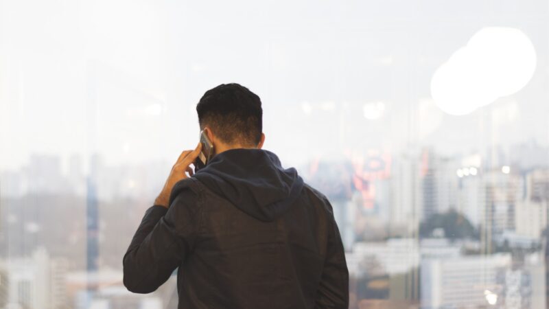 Person taking a phone call, illustrating checks for bank impersonation scams.