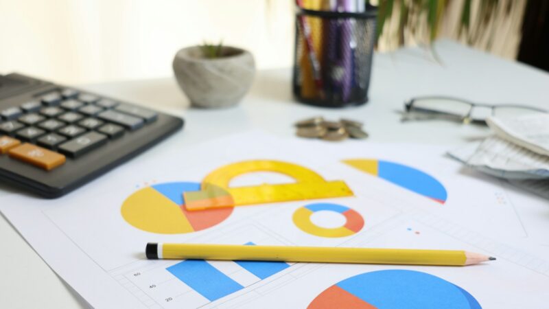 Charts, calculator and coins used to review dividend income planning