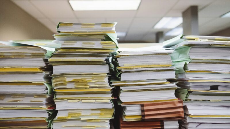 Customer concentration paperwork and annual reports spread across a desk