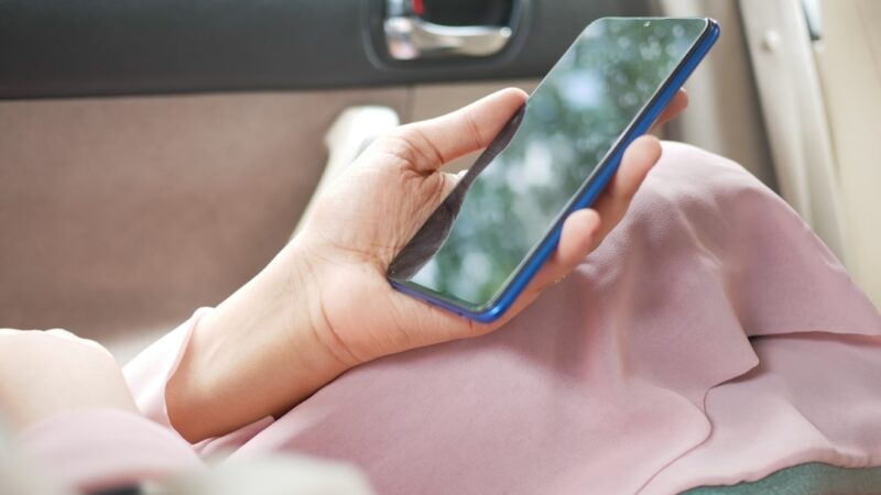 Person using a smartphone near a car door for digital car key security