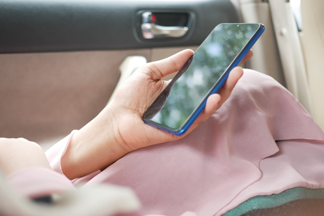 Person using a smartphone near a car door for digital car key security