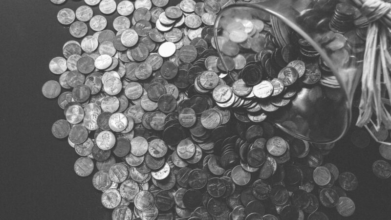 Coins spilling from a glass savings jar.
