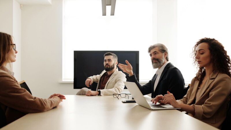 Company leaders seated around a table during a business meeting.