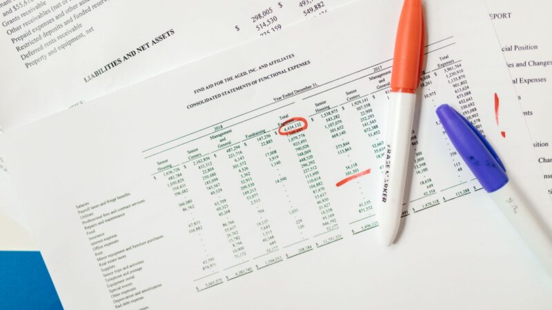 Close-up of financial documents with highlighted figures and marker pens.